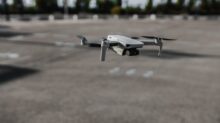 white and black drone on gray concrete ground during daytime