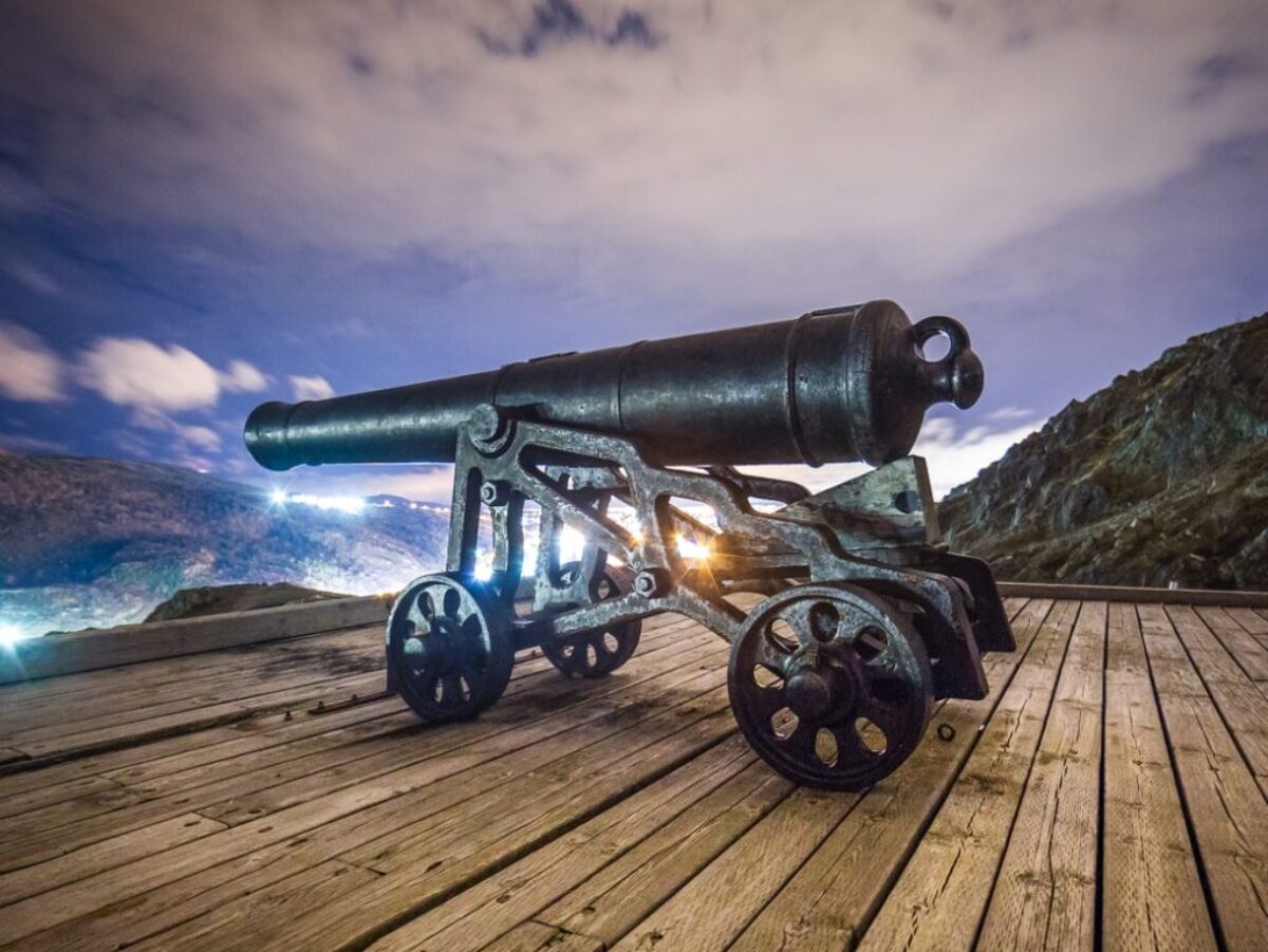 black antique cannon on brown wooden platform