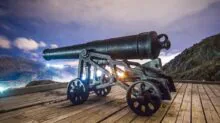 black antique cannon on brown wooden platform