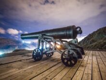 black antique cannon on brown wooden platform