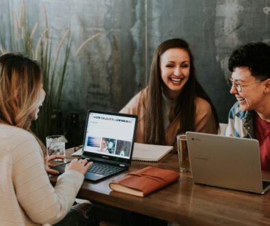 three people sitting in front of table laughing together