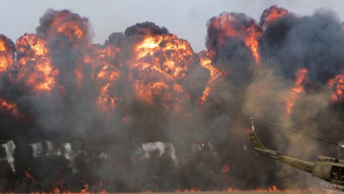 green helicopter near big fire