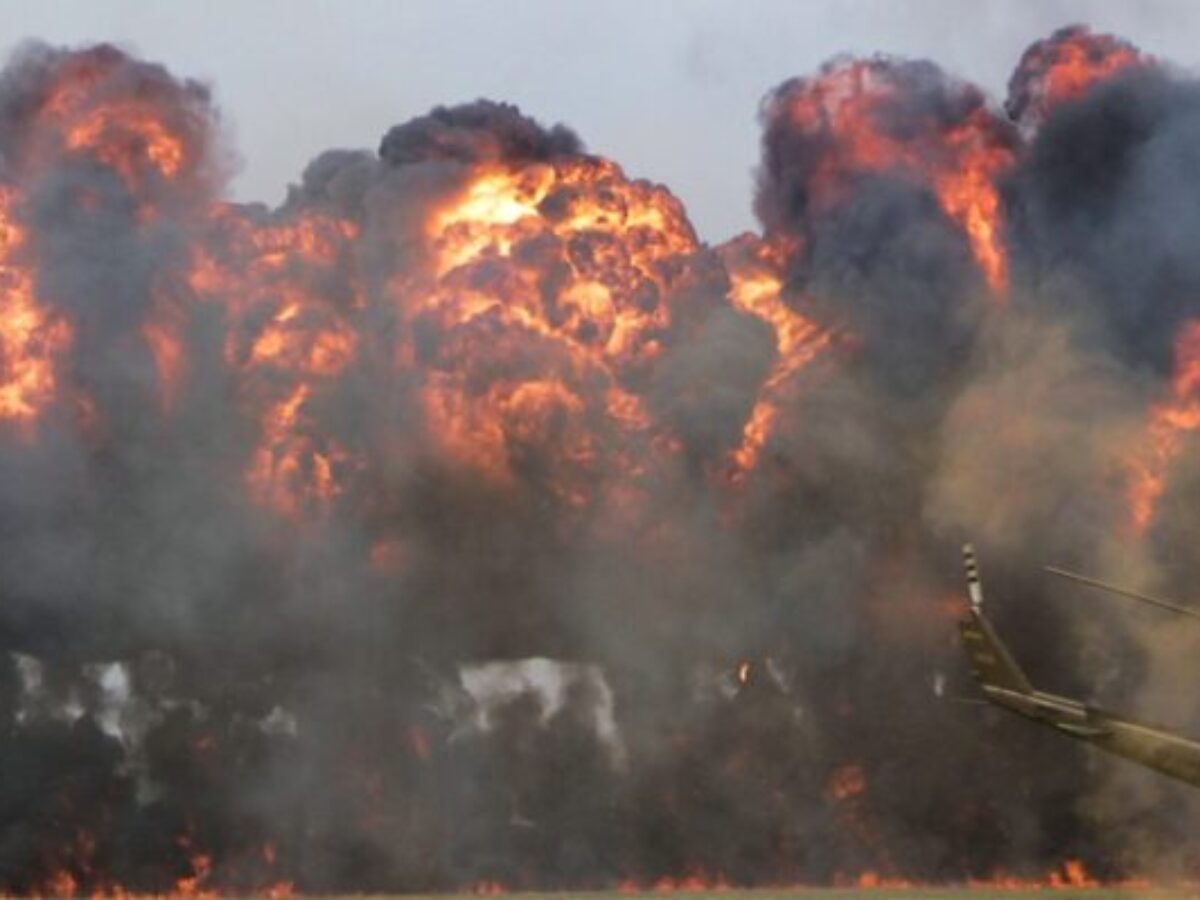 green helicopter near big fire