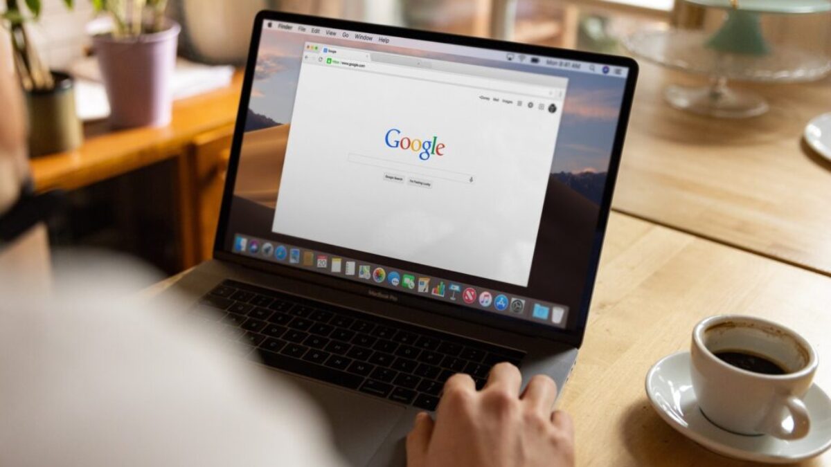 person using macbook pro on table