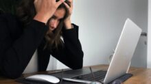 woman in black long sleeve shirt covering her face with her hands