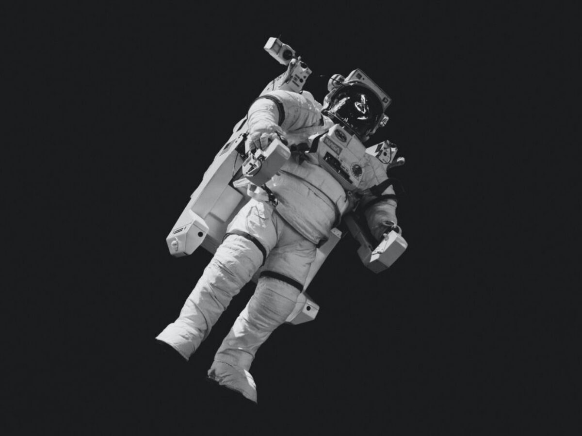 astronaut in white suit in grayscale photography