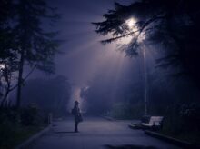 person looking at street lamp