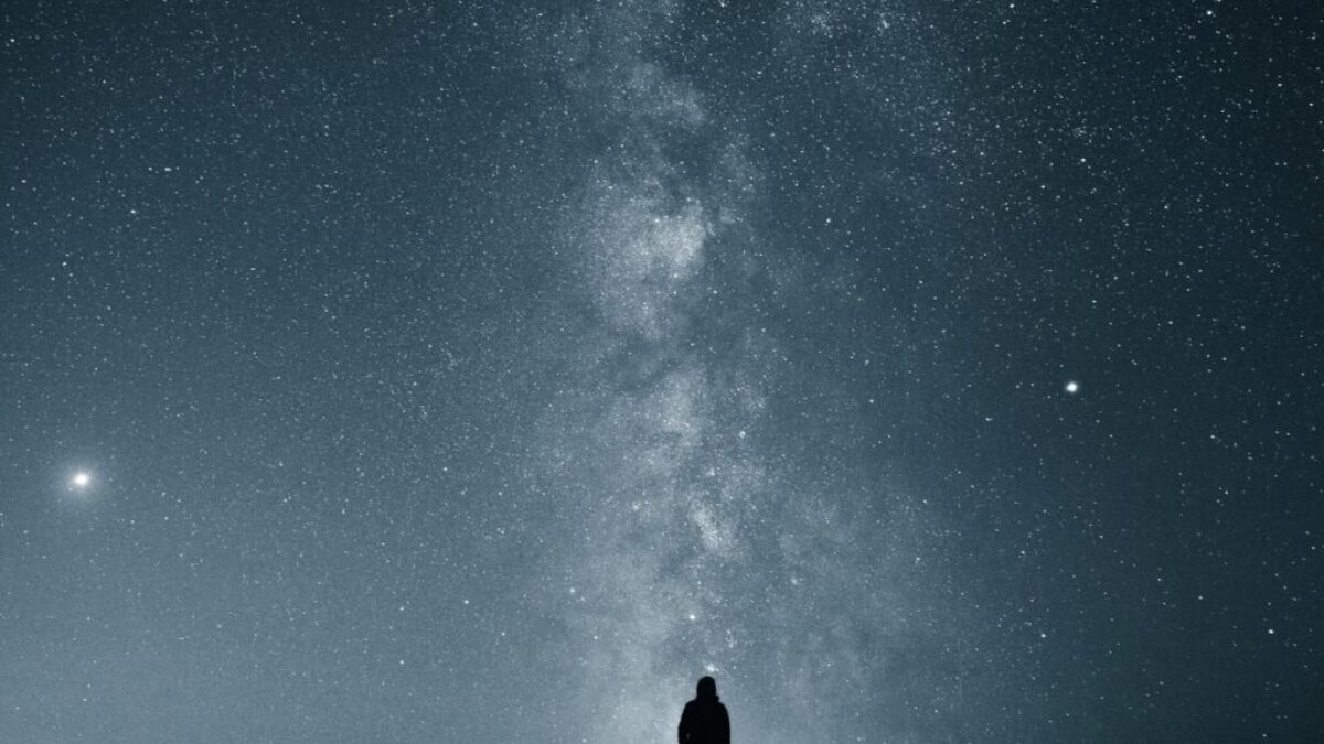 silhouette of person under starry sky