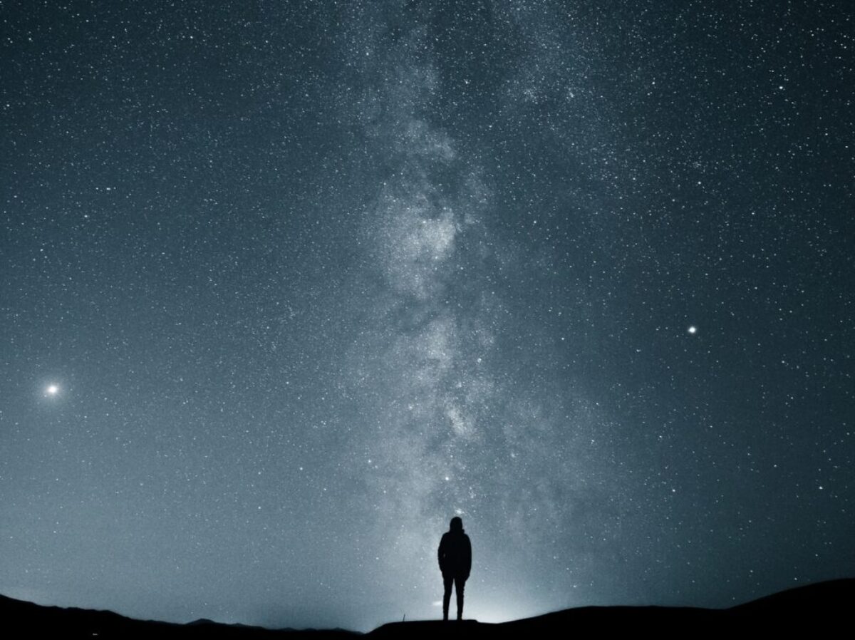 silhouette of person under starry sky