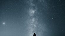 silhouette of person under starry sky