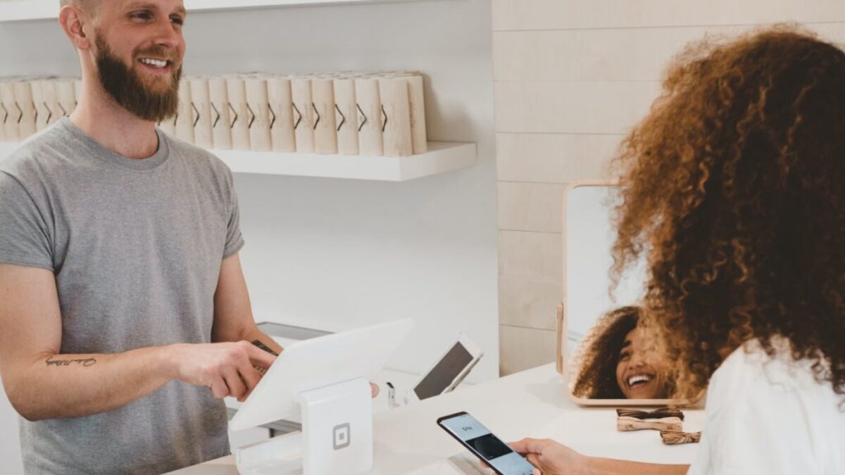 man in grey crew-neck t-shirt smiling to woman on counter