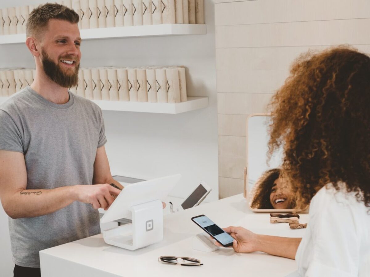 man in grey crew-neck t-shirt smiling to woman on counter
