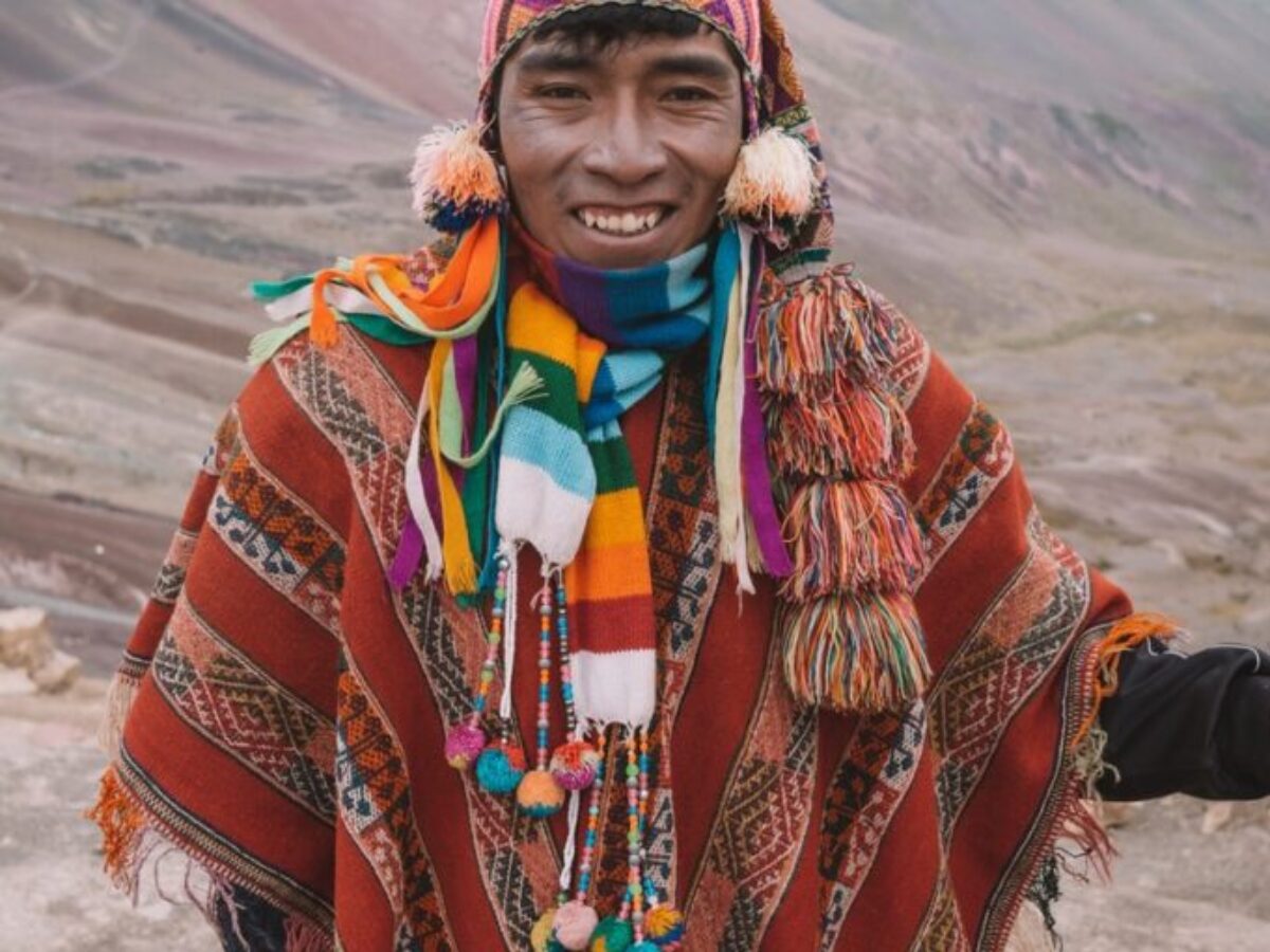 smiling man standing in front of mountains during day
