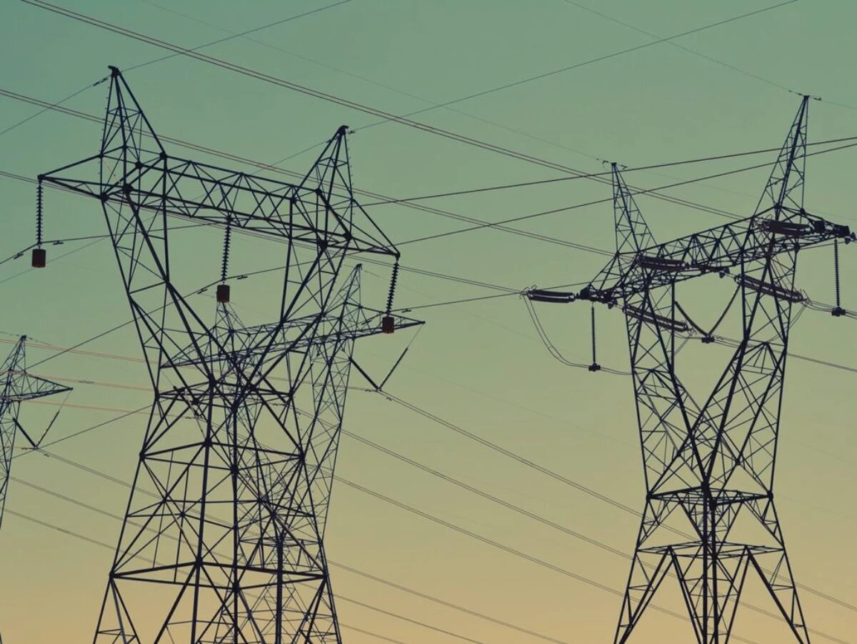 black transmission towers under green sky