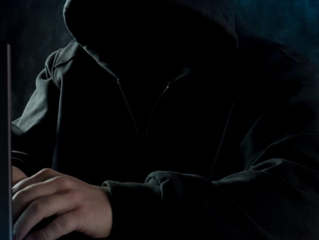 person in black hoodie using laptop computer