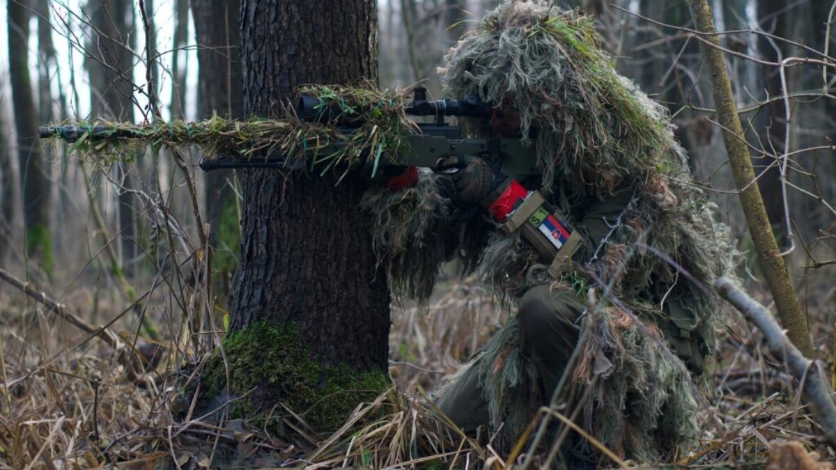 person holding green rifle shooting
