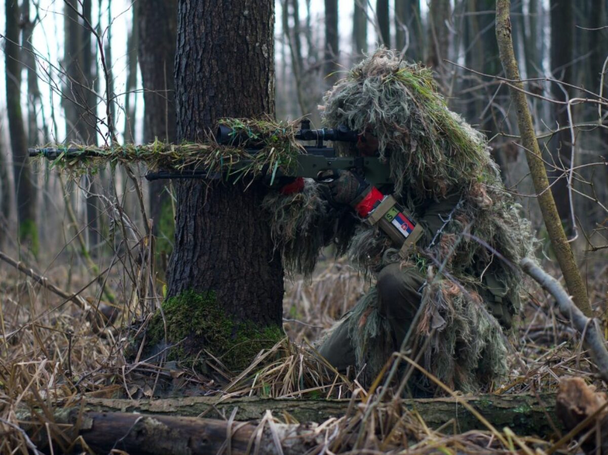 person holding green rifle shooting