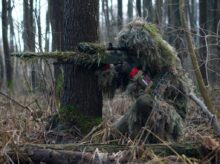 person holding green rifle shooting