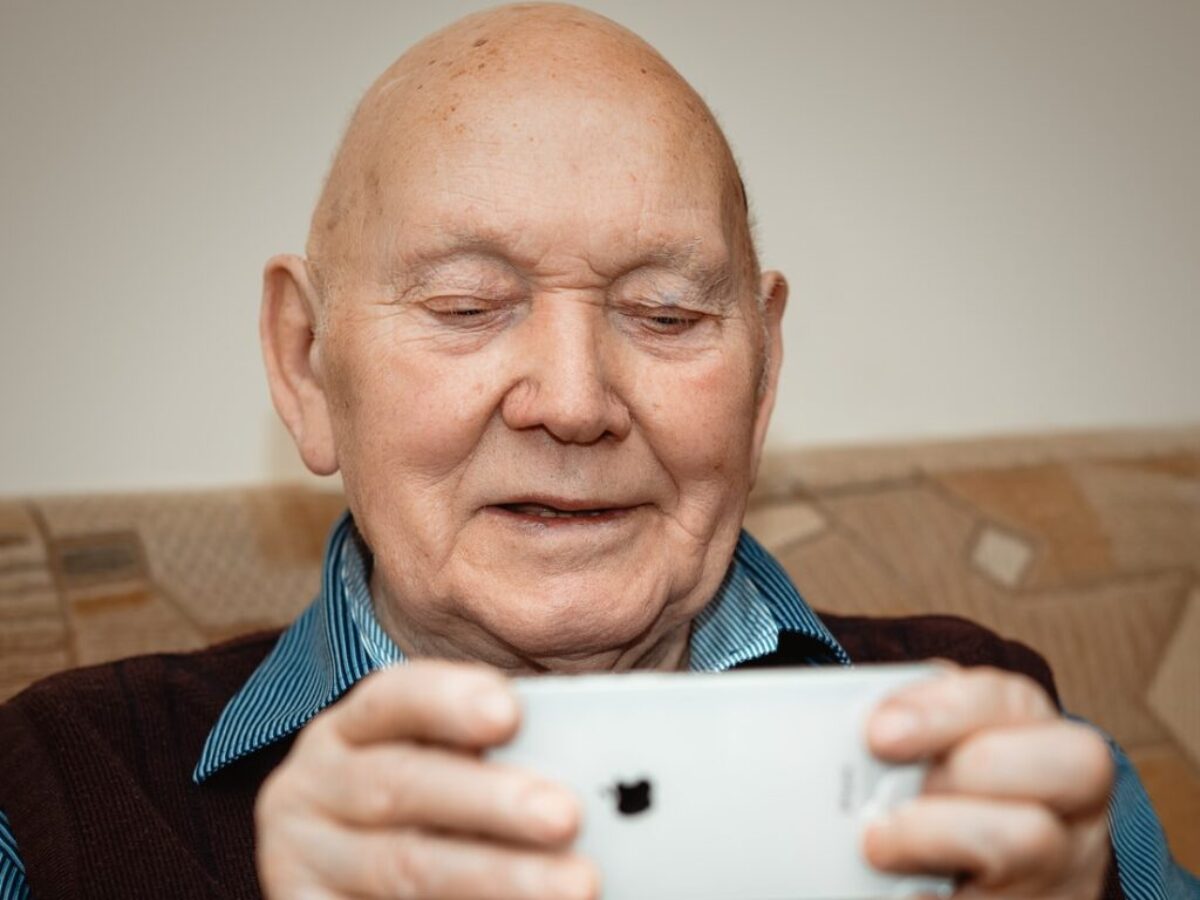 man in blue and black pinstripe dress shirt holding white smartphone