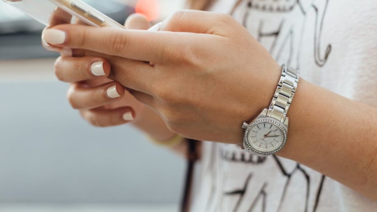 woman holding iPhone during daytime