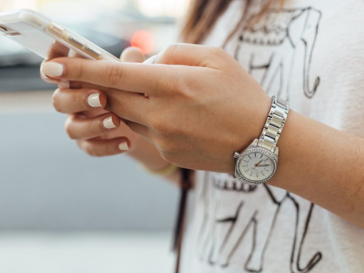 woman holding iPhone during daytime