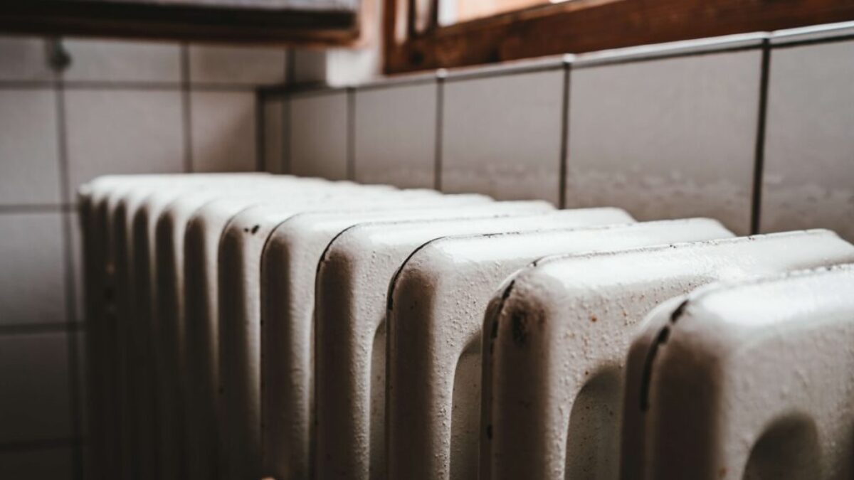 white radiator heater beside brown wooden window