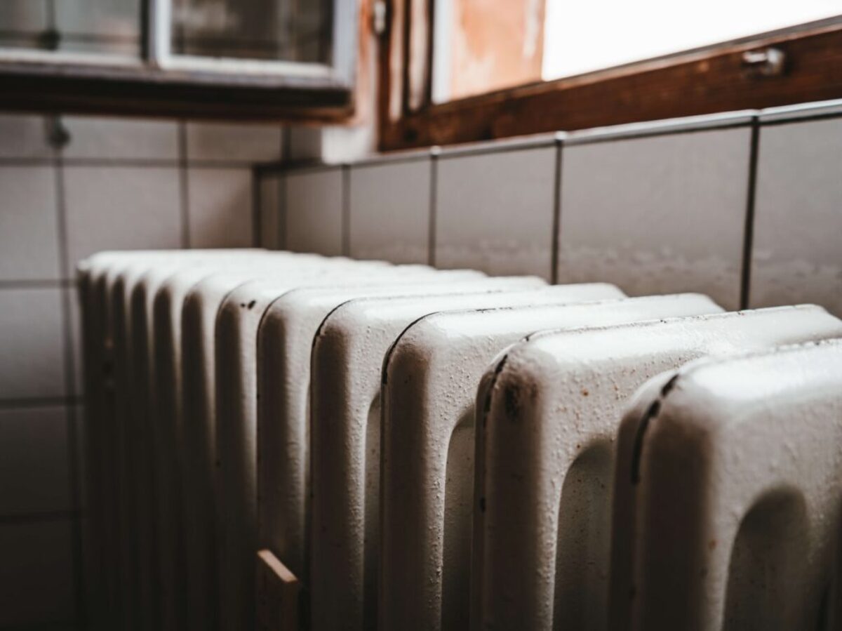 white radiator heater beside brown wooden window
