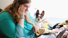 woman in teal long sleeve shirt holding black laptop computer