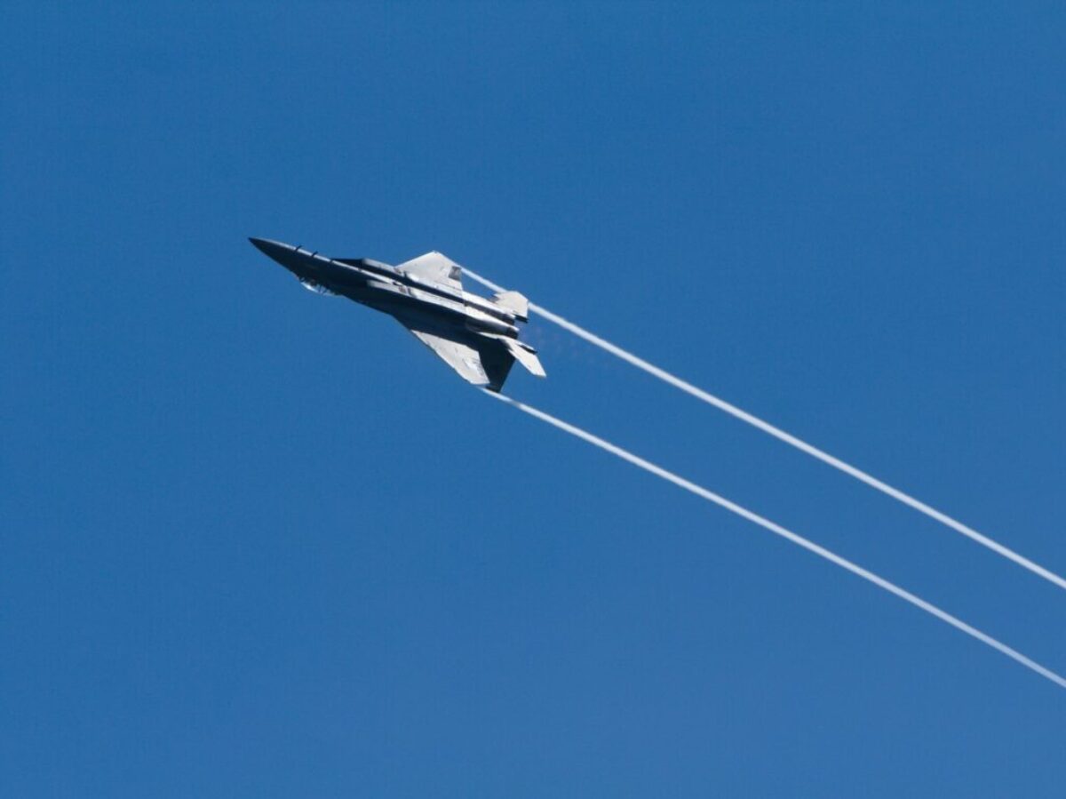 gray jet plane in mid air during daytime