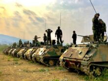 soldiers on top of battle tanks