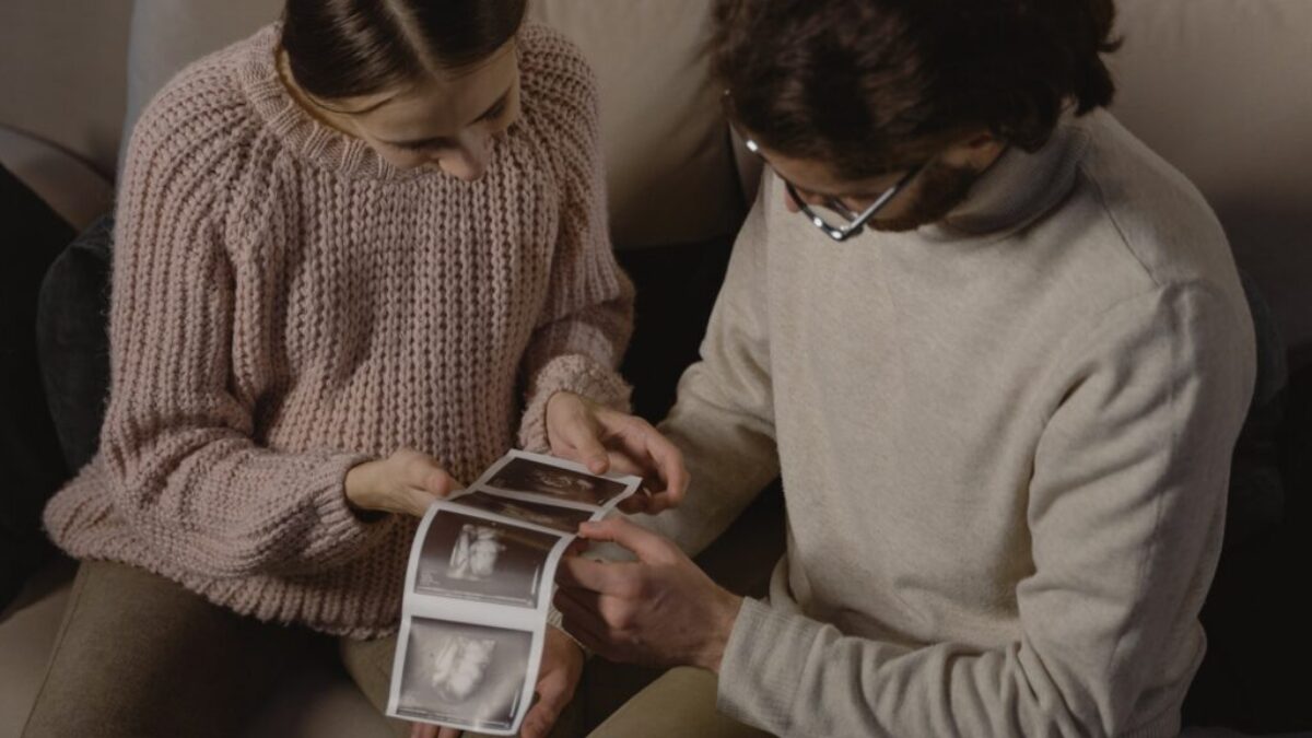 A Man and Woman Holding Ultrasound Images