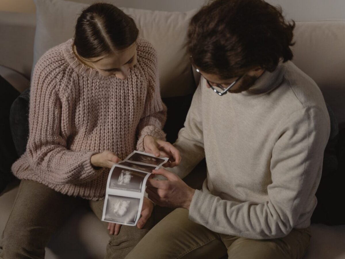 A Man and Woman Holding Ultrasound Images