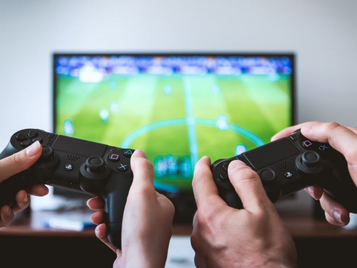 two people playing Sony PS4 game console