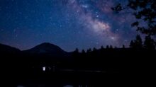 silhouette of mountain near body of water during night time