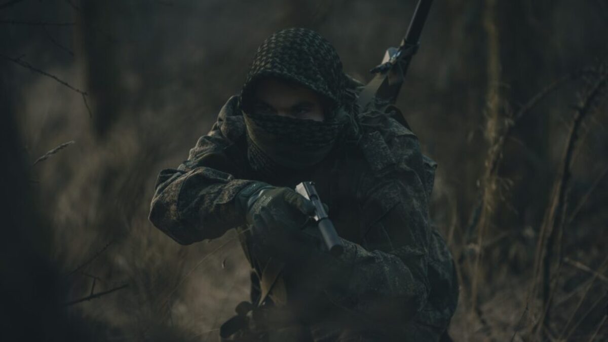 person in black and white hoodie holding rifle