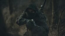 person in black and white hoodie holding rifle