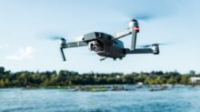 black DJI Mavi quadcopter near body of water