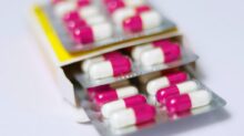 white and red medication pill on yellow box