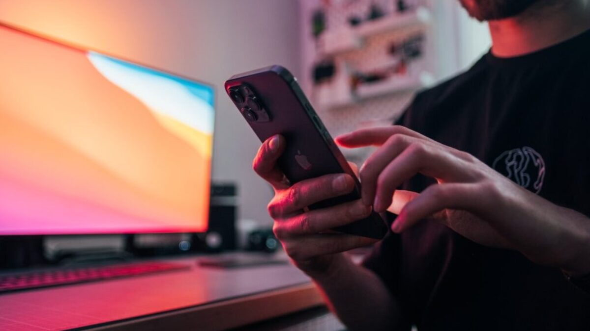 man in black shirt holding black iphone 5