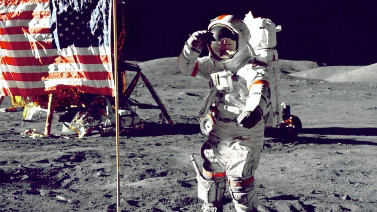astronaut standing on moon beside U.S.A. flag