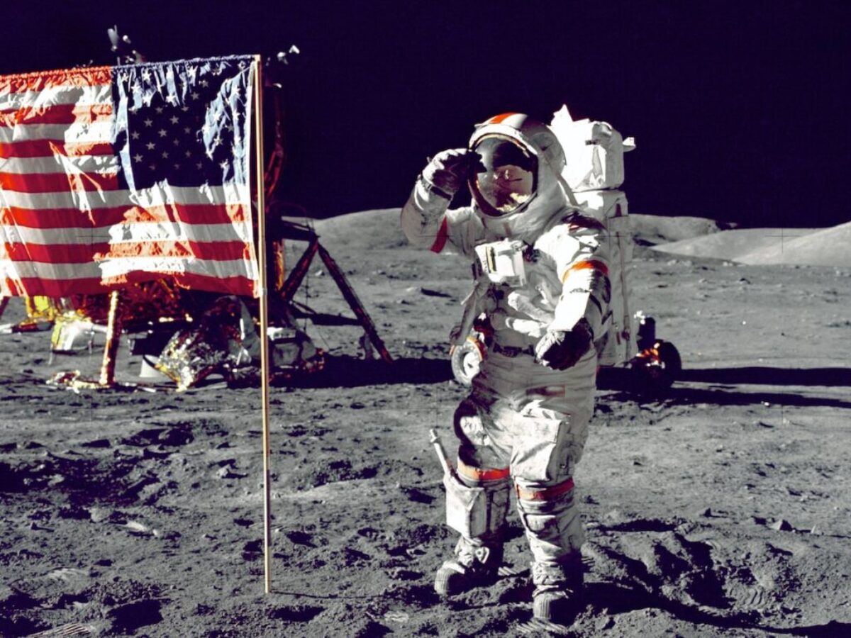 astronaut standing on moon beside U.S.A. flag