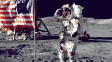 astronaut standing on moon beside U.S.A. flag