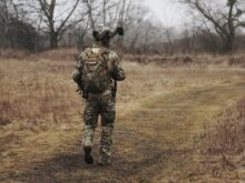 man walking on brown grass field
