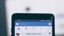 person holding smartphone using facebook account