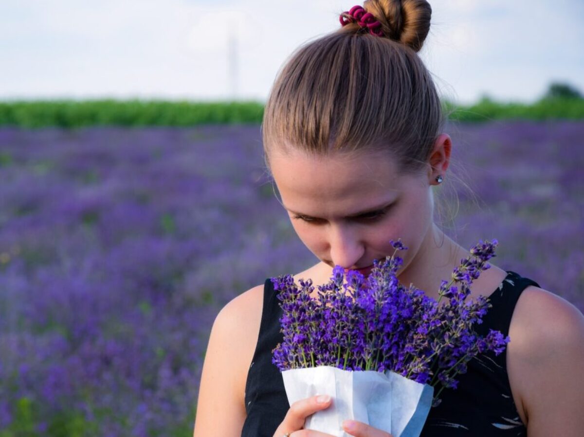 woman smelling bouquet of purple lavender