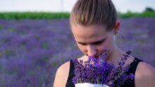 woman smelling bouquet of purple lavender