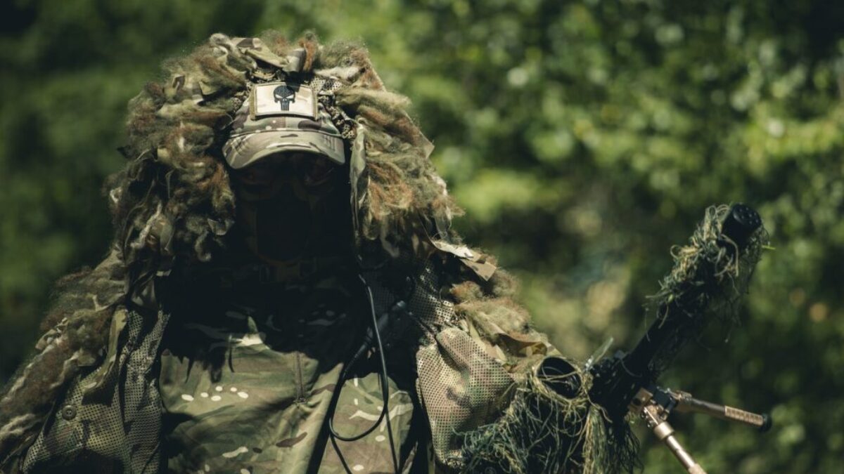 man in green and brown camouflage uniform holding rifle