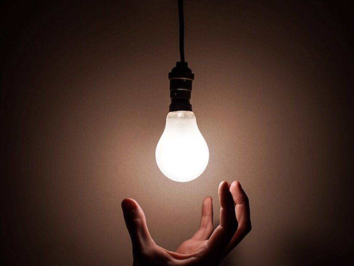 Person Holding White Light Bulb
