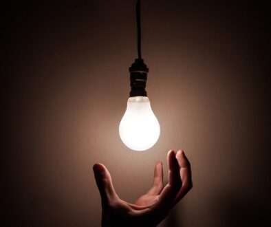 Person Holding White Light Bulb