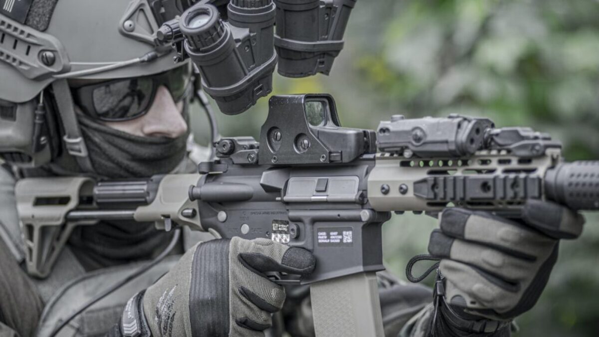 person holding grey and black rifle